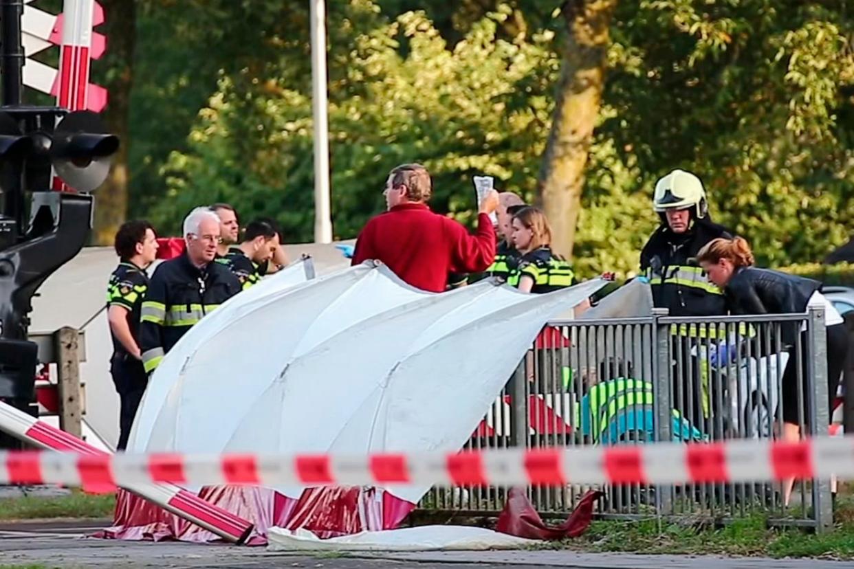 Emergency services at the scene in Oss after a train collided with a bike, killing four children: Charles Mallo/AP