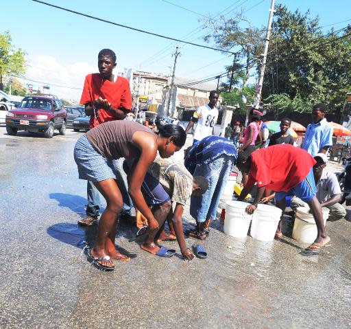 Un grupo de personas recogen agua de un caño roto en Puerto Príncipe el 1 de febrero de 2011 (AFP/Archivos | Thony Belizaire)