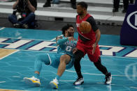 Charlotte Hornets forward Miles Bridges passes around Portland Trail Blazers forward Norman Powell during the first half in an NBA basketball game on Sunday, April 18, 2021, in Charlotte, N.C. (AP Photo/Chris Carlson)