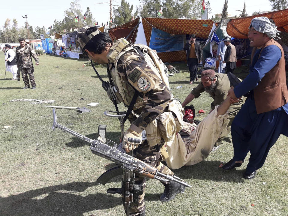 A wounded man is tended to following multiple explosions in Lashkar Gah city of Helmand province, southern Afghanistan, Saturday, Mar. 23, 2019. An Afghan official says that at least three have been killed in twin bomb explosions occurred during the Farmer’s Day ceremony in southern Helmand province. (AP Photo/Abdul Khaliq)