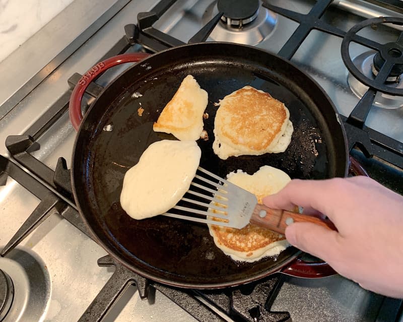 <span>My husband cooking pancakes (the pan is <a href="http://www.anrdoezrs.net/links/8430591/type/dlg/sid/KTThePracticallyPerfectPancakeRecipeIMakeOverandOverAgain/https://www.zwilling.com/us/staub-cast-iron-12-inch-round-griddle-cherry-12293006/40501-056-0.html" rel="nofollow noopener" target="_blank" data-ylk="slk:this great cast iron griddle from Staub;elm:context_link;itc:0;sec:content-canvas" class="link ">this great cast iron griddle from Staub</a>). Credit: Faith Durand / Kitchn</span> <span class="copyright">Credit: Faith Durand / Kitchn</span>