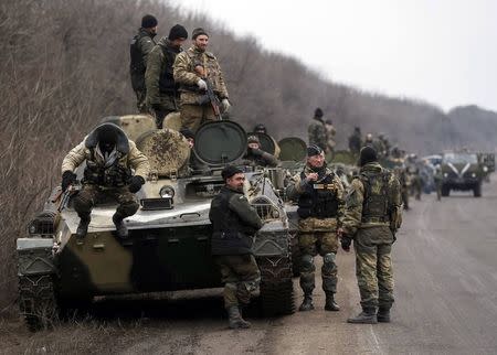 Members of the Ukrainian armed forces and armoured personnel carriers are seen preparing to move as they pull back from Debaltseve region, near Artemivsk February 26, 2015. REUTERS/Gleb Garanich