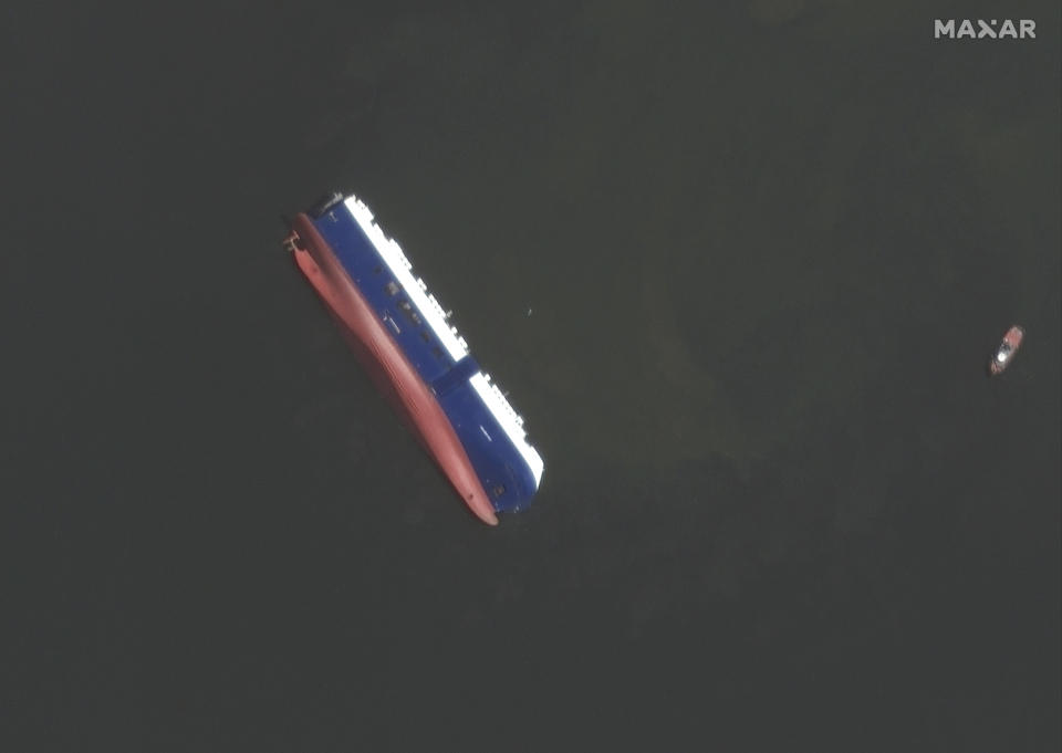 This Sept. 10, 2019 satellite photo provided by Maxar Technologies, shows the capsized cargo shop Golden Ray in Jekyll Island, Ga. A fire broke out aboard the ship early Sunday, listing it to the side and blocking the shipping channel. The Coast Guard and a salvage crew freed the four remaining Golden Ray crew members. (Satellite image ©2019 Maxar Technologies via AP)