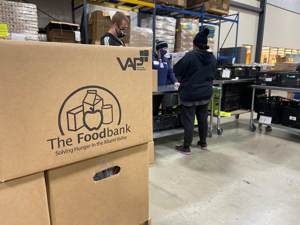 Volunteers fill backpacks for one of the food programs run out of The Foodbank Inc. in Dayton, Ohio, on Nov. 15, 2021.