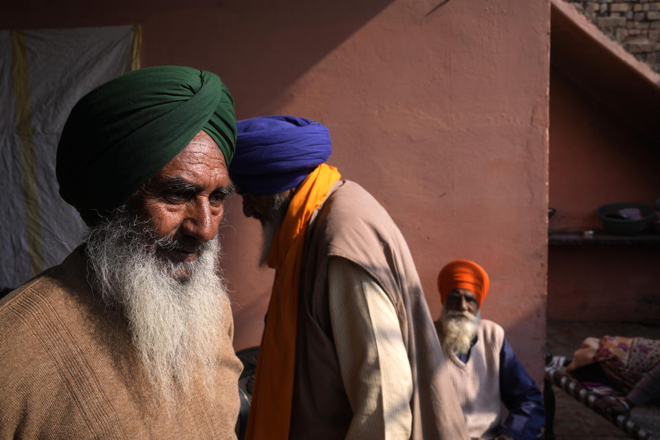 Charan Singh, 72, the village head, left, visits the house of his friend, Sudagar Singh who died during farm protests, in Kaler Ghuman village, some 40 kilometers (24 miles) from Amritsar in Amritsar, in Indian state of Punjab, Tuesday, Feb. 15, 2022. "Even though we won in the end, those laws only brought misery to our lives. Do you think we would forget that?" said Singh. India's Punjab state will cast ballots on Sunday that will reflect whether Indian Prime Minister Narendra Modi's ruling Bharatiya Janata Party has been able to neutralize the resentment of Sikh farmers by repealing the contentious farm laws that led to year-long protests. (AP Photo/Manish Swarup)