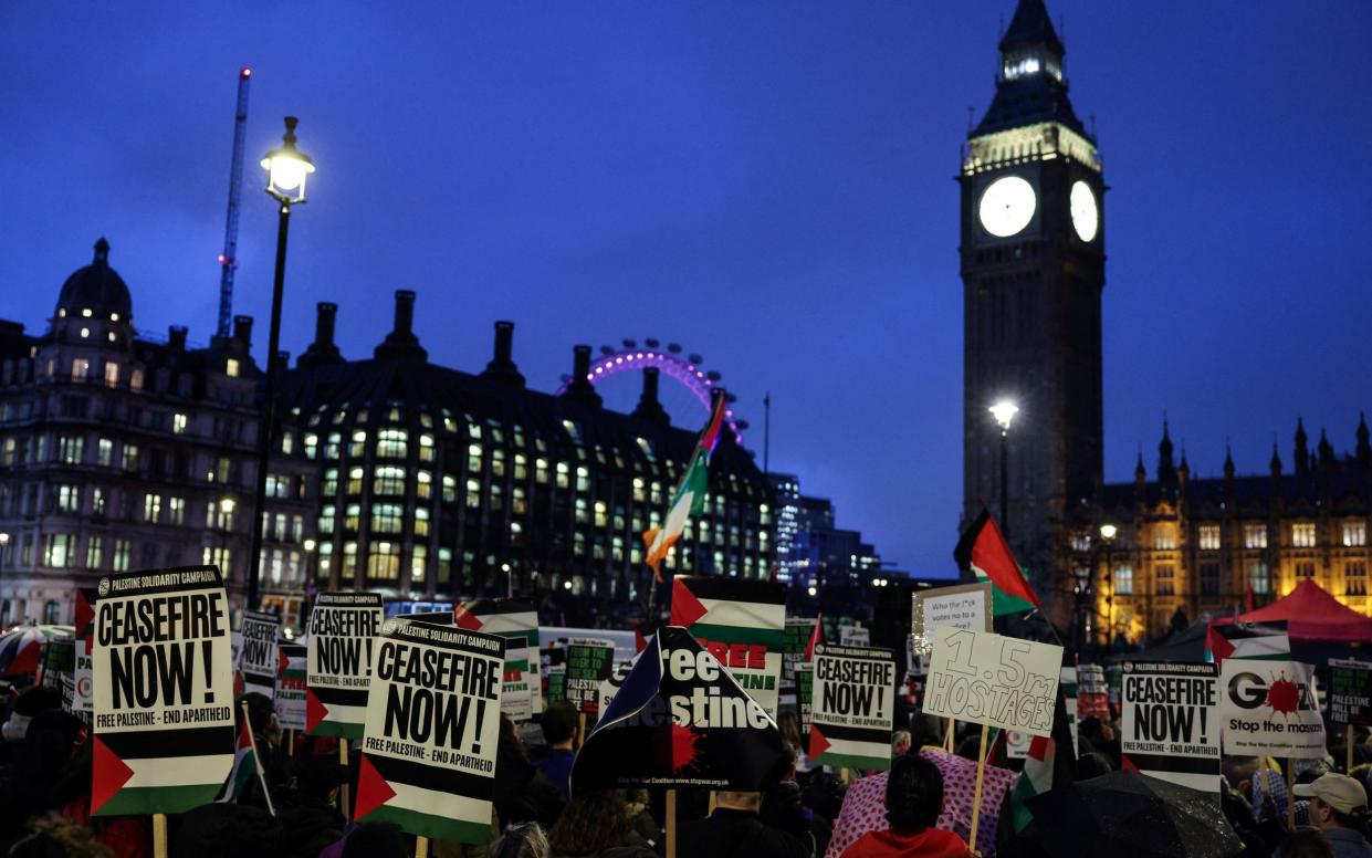 Pro-Palestinian demonstrators wave Palestinian flags and hold placards as they protest in Parliament Square
