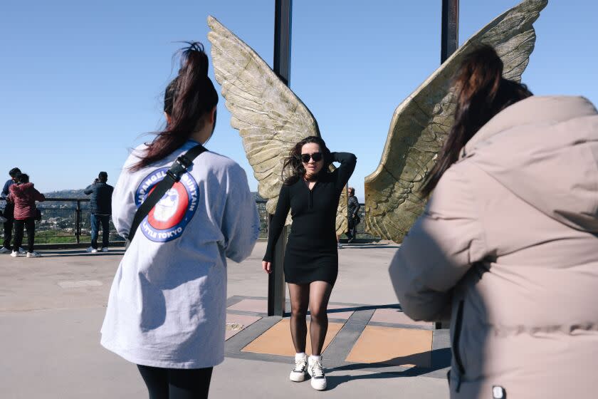 Los Angeles, CA - January 23: Charley Liang, center, is photographed on a day where a high wind warning is issued for parts of the county at Griffith Observatory on Monday, Jan. 23, 2023 in Los Angeles, CA. North winds from 25 to 40 miles per hour with damaging gusts up to 60 miles per hour were expected. (Dania Maxwell / Los Angeles Times).