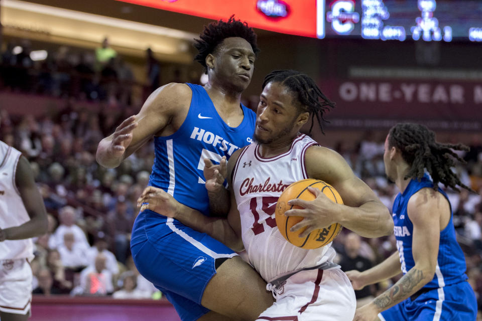 Charleston guard Pat Robinson III (15) drives against Hofstra guard Darlinstone Dubar, left, during the first half of an NCAA college basketball game, Saturday, Jan. 28, 2023, in Charleston, S.C. (AP Photo/Stephen B. Morton)