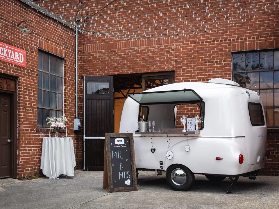 A trailer being used as a bar at a wedding.