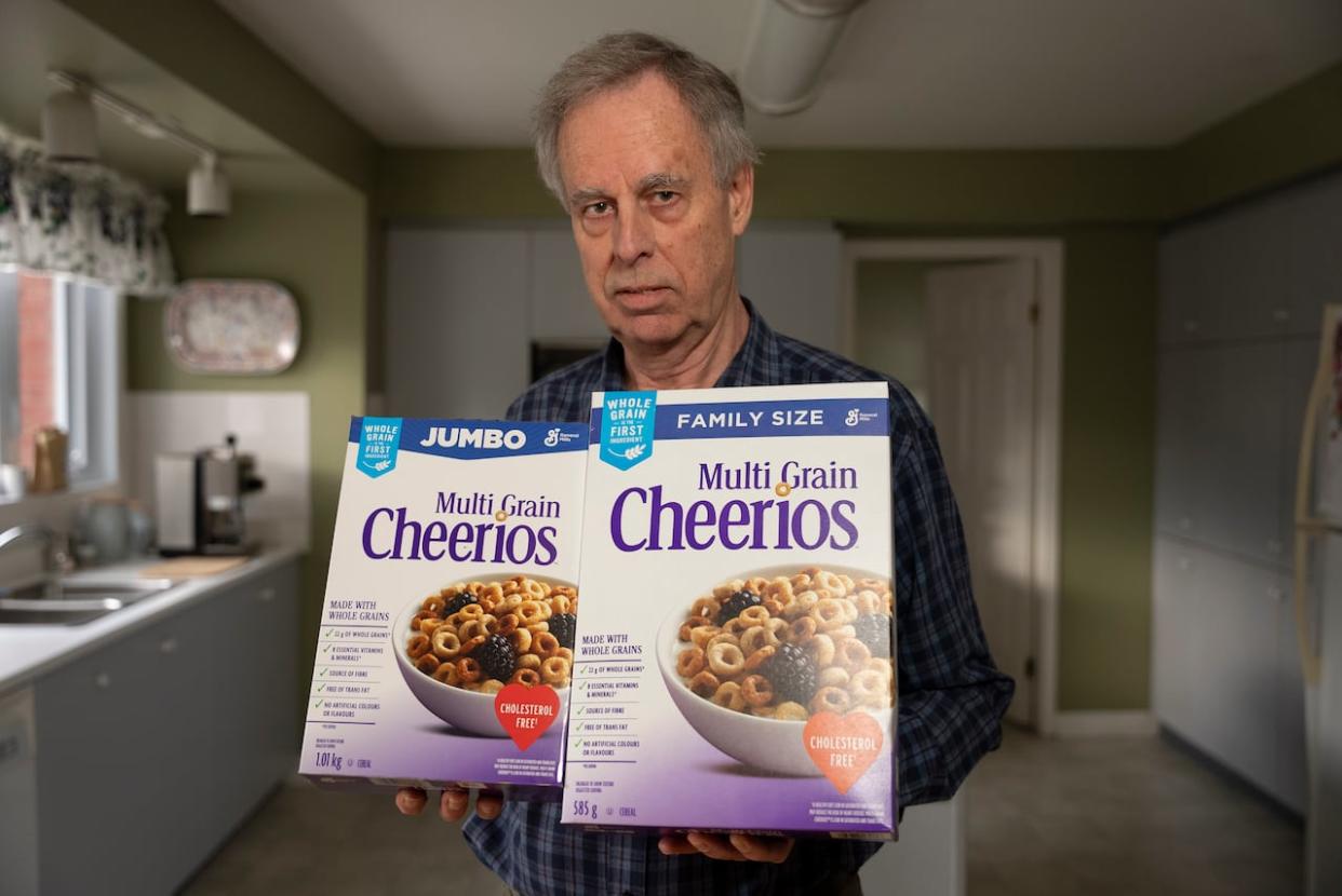 Weighed and found wanting: Paul Jay of Ottawa holds boxes of Cheerios that have weights printed on them double what is actually inside.  (Marc Robichaud/CBC - image credit)