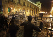 Anti-government protesters throw stones and clash with the riot police, during ongoing protests against the political elites who have ruled the country for decades, in Beirut, Lebanon, Sunday, Jan. 19, 2020. Lebanese security forces used tear gas, water cannons and rubber bullets in clashes with hundreds of anti-government protesters outside the country's Parliament on Sunday, as violence continued to escalate in a week of rioting in the capital. (AP Photo/Hassan Ammar)