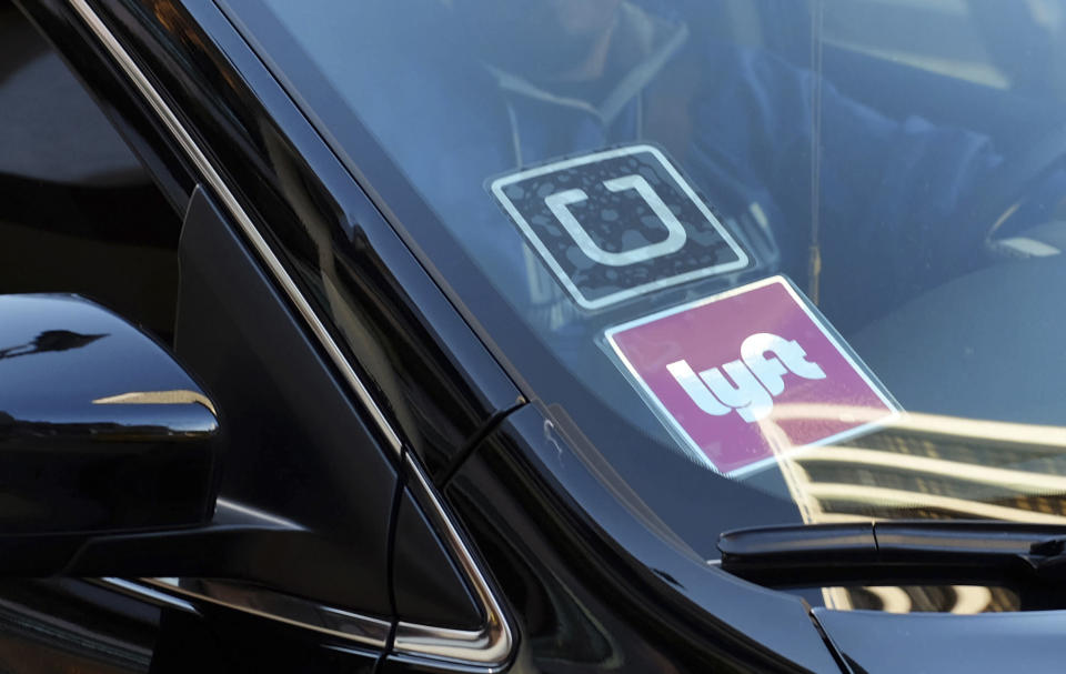 Íconos de Uber y Lyft en un carro de servicios. (Foto: AP)