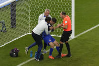 Christian Pulisic of the United States is helped by referee Antonio Mateu, of Spain, and team doctors after he scoring his side's opening goal during the World Cup group B soccer match between Iran and the United States at the Al Thumama Stadium in Doha, Qatar, Tuesday, Nov. 29, 2022. (AP Photo/Luca Bruno)