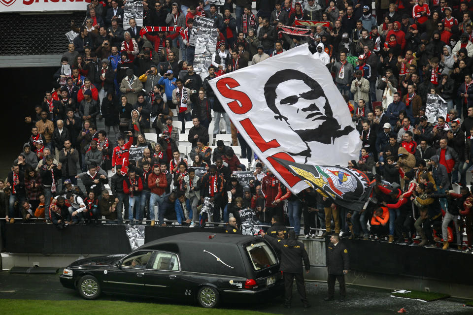 The remains of the Portuguese soccer player legend Eusebio are carried inside a car as supporters cheer during his memorial tribute at the Benfica's Luz stadium in Lisbon, Monday, Jan. 6, 2014. Eusebio, the Portuguese football star who was born into poverty in Africa but became an international sporting icon and was voted one of the 10 best players of all time, has died aged 71, his longtime club Benfica said. Few supporters hold posters with the photograph of Esusebio that read in Portuguese: "Bye King". (AP Photo/Francisco Seco)