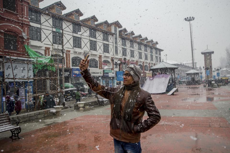 An Indian tourist take a selfie as it snows in Srinagar, Indian controlled Kashmir, Saturday, Jan. 28, 2017. Authorities in Indian-controlled Kashmir have issued avalanche warnings for many parts of the region, as the heavy snowfall has cut off roads, disrupted power and communication lines, and forced the evacuation of hundreds of residents. (AP Photo/Dar Yasin)