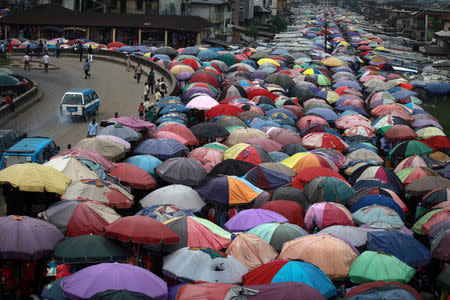 FILE PHOTO: Street traders covers stalls with umbrellas along abandoned railway line in Nigeria's oil hub city of Port Harcourt December 3, 2012. REUTERS/Akintunde Akinleye/File Photo