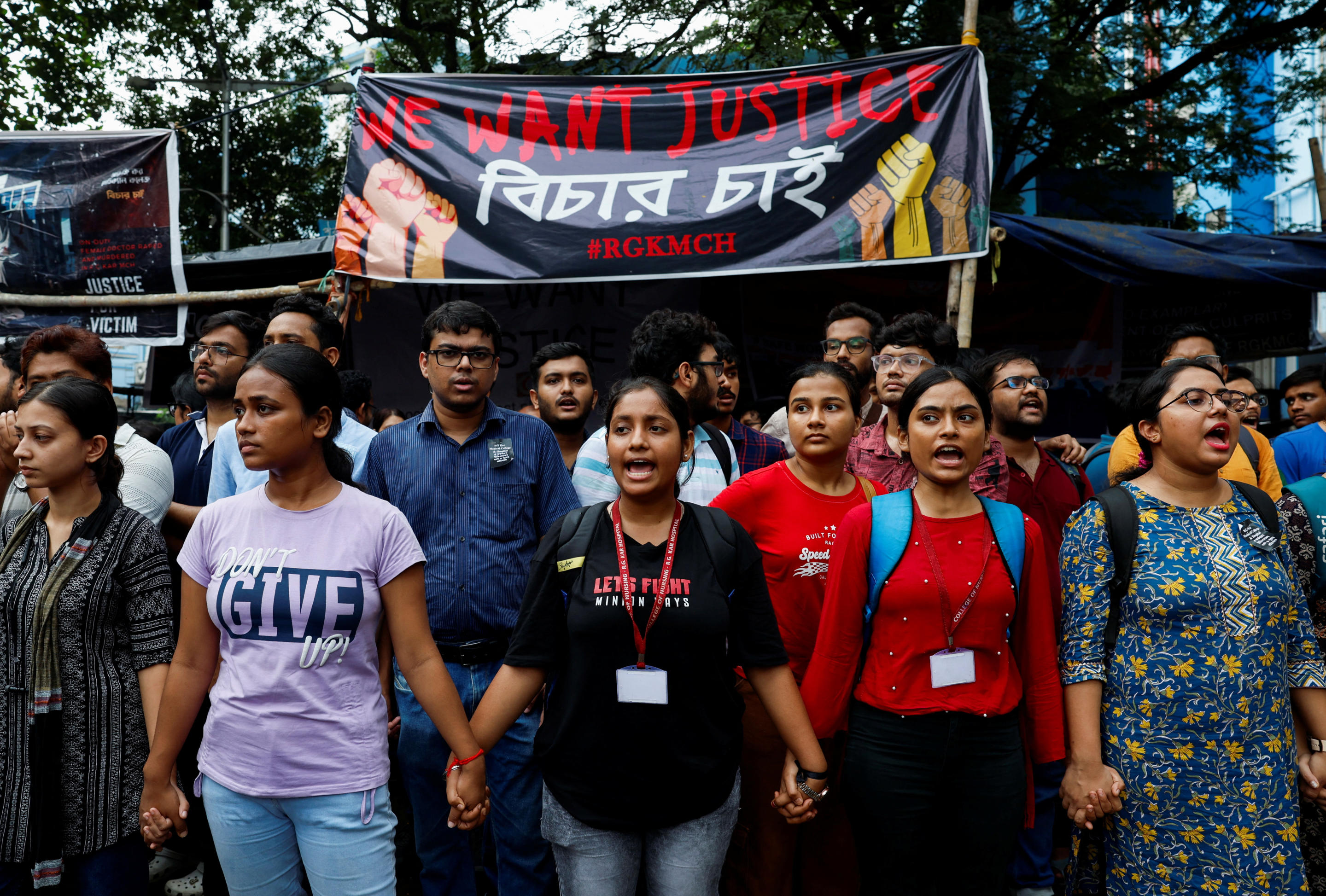 Medical students hold hands as they attend a protest on Wednesday against the rape and killing of a trainee doctor.