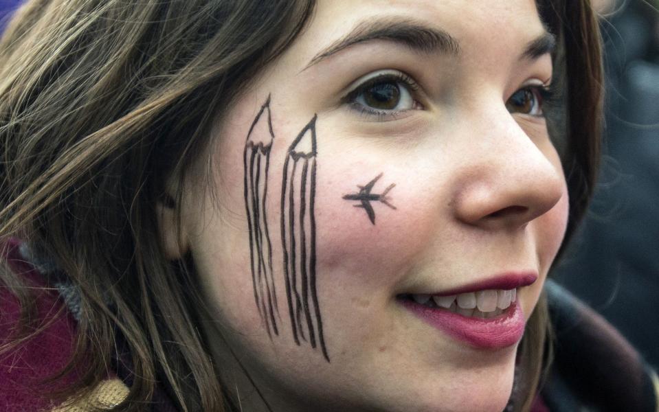 A woman wears a cartoon painting on the face during a silent protest for the victims of the shooting at the Paris offices of weekly newspaper Charlie Hebdo, at the Pariser Platz square in Berlin