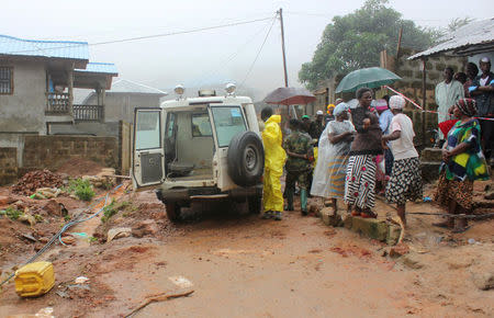 Residents stand near an ambulance after a mudslide in the mountain town of Regent, Sierra Leone August 14, 2017. REUTERS/Ernest Henry