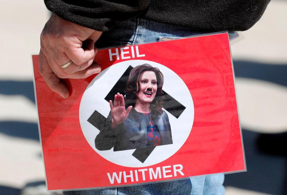 A protester with a sign comparing Gretchen Whitmer’s to Hitler over lockdown orders (AFP via Getty Images)