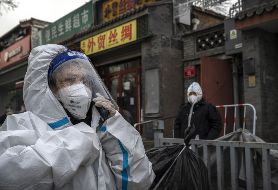 Una trabajadora de control de epidemias usa equipo de protección personal mientras su protector facial está empañado por el frío mientras espera afuera de una comunidad en un encierro por COVID-19 el 2 de diciembre de 2022 en Beijing, China.  (Foto de Kevin Fryer/Getty Images)