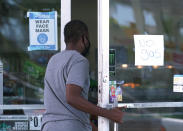 A customer asks a Chevron gas station cashier when they expect gasoline to be delivered, Wednesday, May 12, 2021, in Miami. State and federal officials are scrambling to find alternate routes to deliver gasoline in the Southeast U.S. after a hack of the nation's largest fuel pipeline led to panic-buying that contributed to more than 1,000 gas stations running out of fuel. The pipeline runs from the Gulf Coast to the New York metropolitan region, but states in the Southeast are more reliant on the pipeline for fuel. Other parts of the country have more sources to tap. (AP Photo/Marta Lavandier)