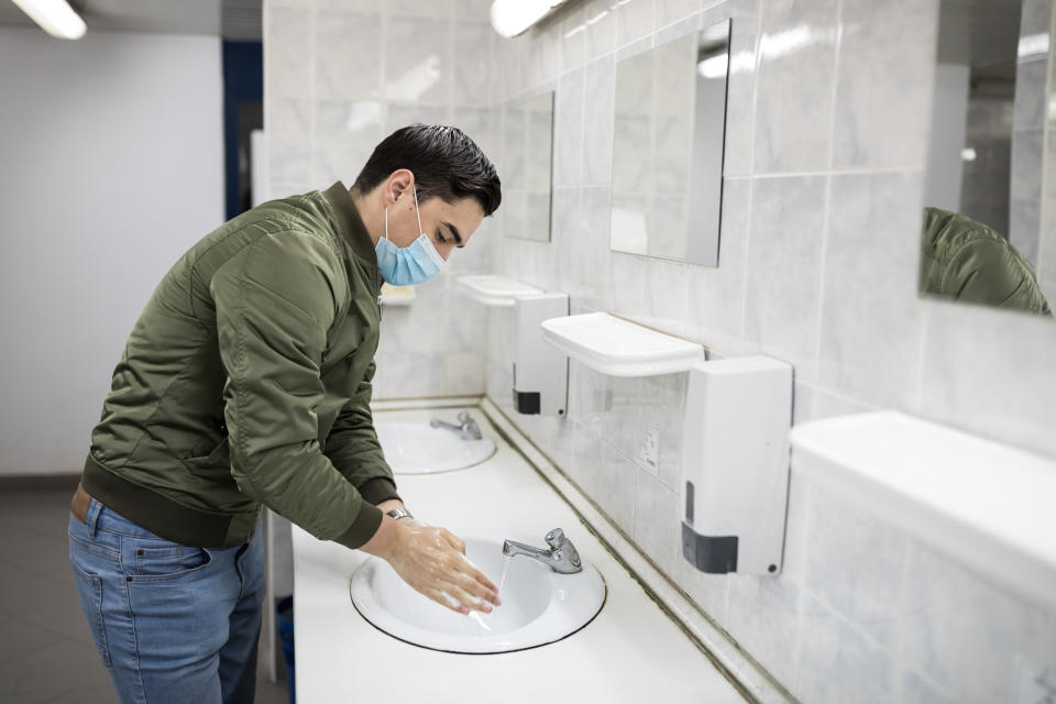 Wash your hands thoroughly when using a public restroom. Don't forget your mask, either.  (Photo: RealPeopleGroup via Getty Images)