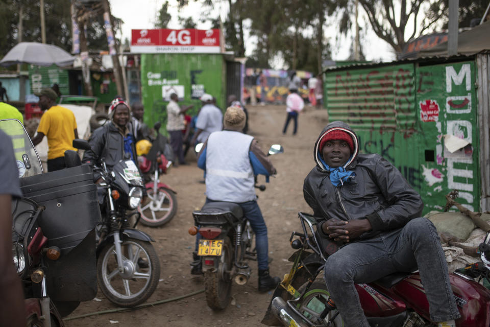 Motorcycle drivers wait for customers in the neighborhood of Kibera, in Nairobi, Kenya, Tuesday, Aug. 16, 2022. Kenya is calm a day after Deputy President William Ruto was declared the winner of the narrow presidential election over longtime opposition figure Raila Odinga. (AP Photo/Mosa'ab Elshamy)