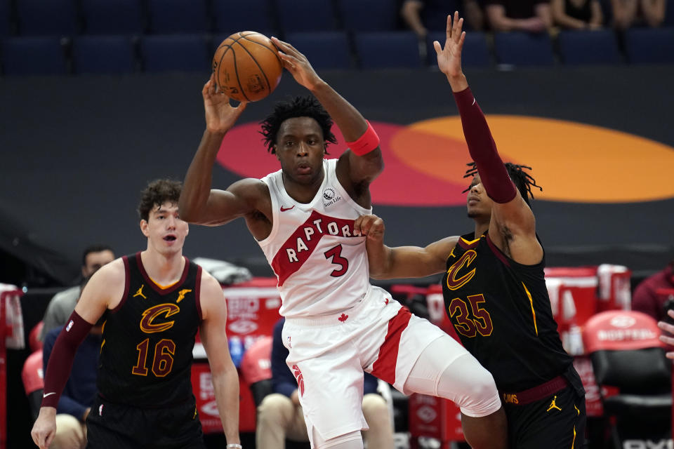 Toronto Raptors forward OG Anunoby (3) pass the ball between Cleveland Cavaliers forward Cedi Osman (16) and forward Isaac Okoro (35) during the second half of an NBA basketball game Monday, April 26, 2021, in Tampa, Fla. (AP Photo/Chris O'Meara)