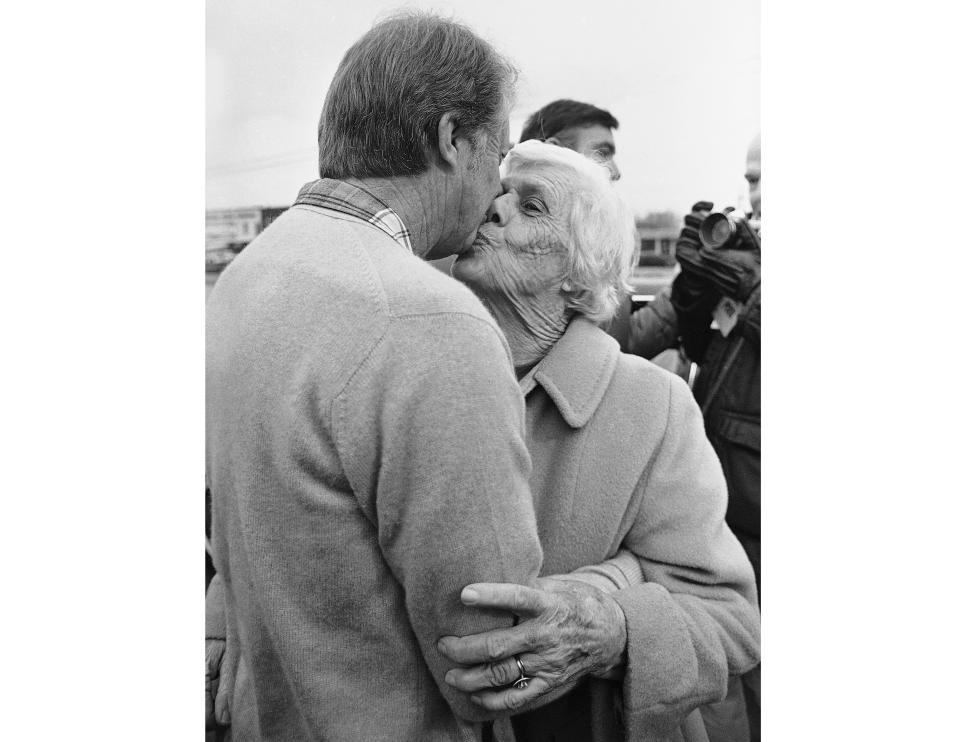 FILE - President-elect Jimmy Carter gets a kiss from his mother, Lillian Carter, after he voted in the election in which his brother Billy Carter is a candidate for mayor, Dec. 6, 1976, in Plains, Ga. When Jimmy Carter stepped onto the national stage, he brought those closest to him along, introducing Americans to a colorful Georgia family that helped shape the 39th president’s public life and now, generations later, is rallying around him for the private final chapter of his 98 years. (AP Photo/File)