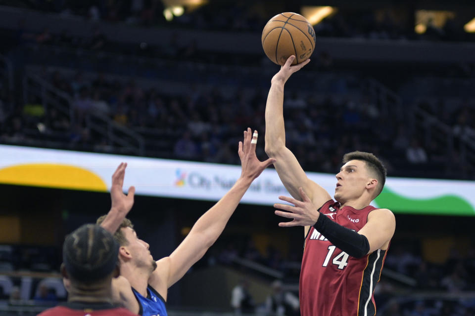 Miami Heat guard Tyler Herro (14) shoots in front of Orlando Magic forward Franz Wagner during the first half of an NBA basketball game, Saturday, March 11, 2023, in Orlando, Fla. (AP Photo/Phelan M. Ebenhack)
