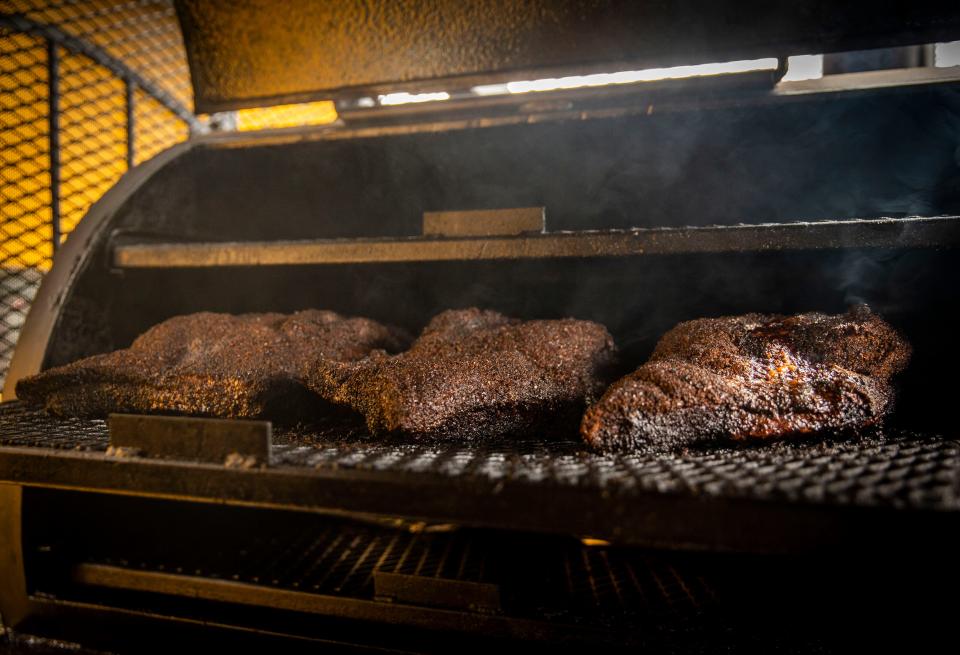 Thickly seasoned meat slow cooks in the Dallas-made smoker at Paper Plate BBQ food truck.