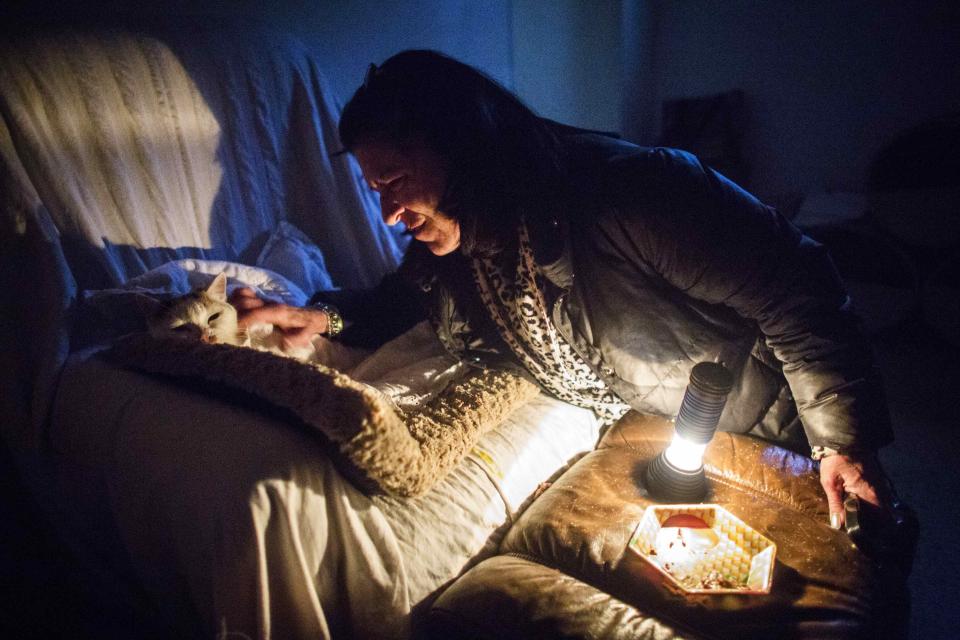 Crawley tends to her cat in her home that has had no heat or power for over 5 days following an ice storm in Toronto