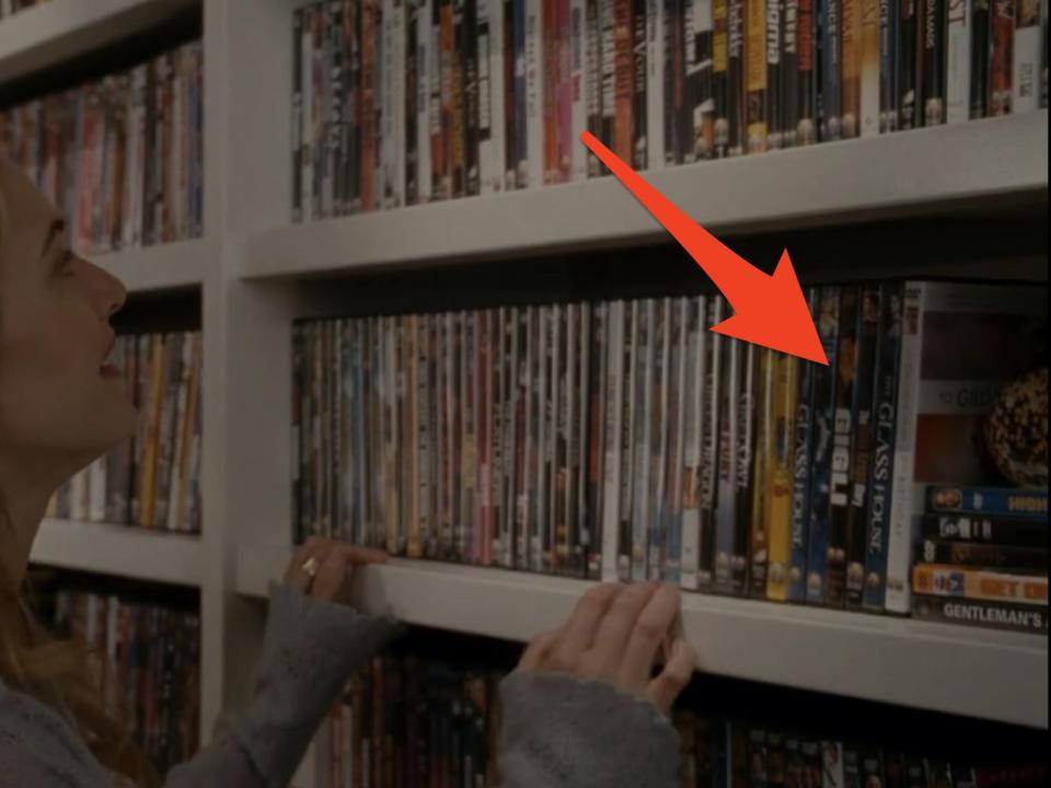 arrow pointing to the "g" section of amanda's dvd collection as iris browses in the holiday