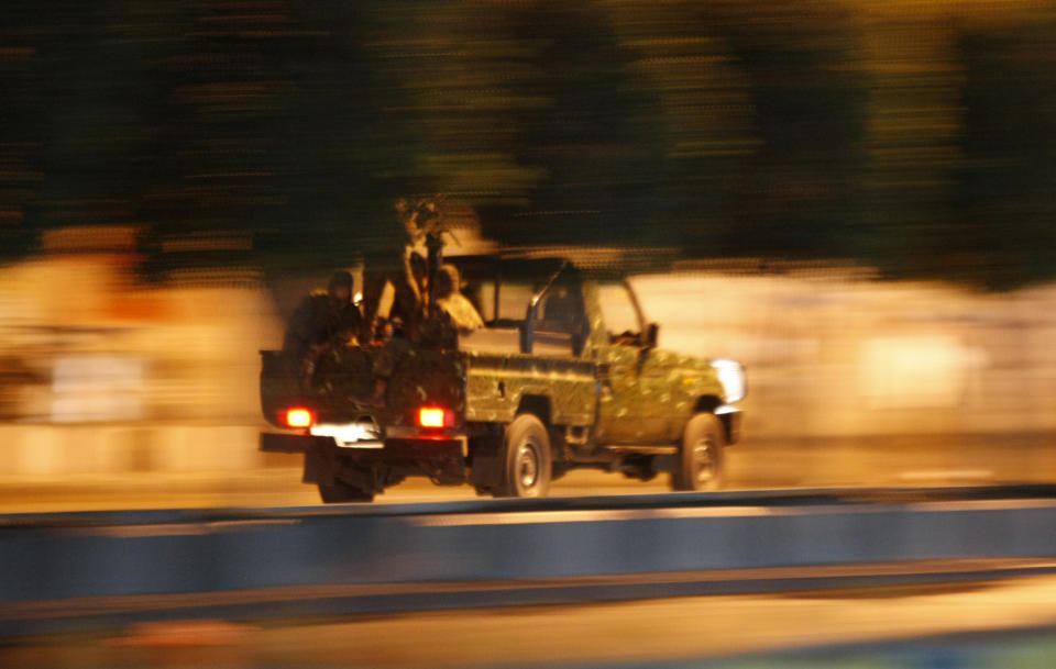 A police vehicle patrols a street leading to the central prison after an explosions that took place nearby in Sanaa, Yemen, Thursday, Feb. 13, 2014. Witnesses said explosions have rocked the Yemeni capital near the central prison followed by heavy gunfire and smoke billowing into the sky. (AP Photo/Hani Mohammed)