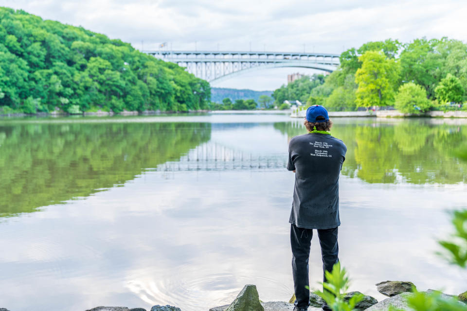 A man looking onto the Hudson River at Inwood Park.