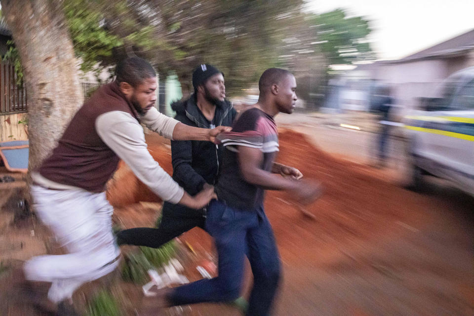 In this Monday, Sept. 2, 2019, photo, Nigerian foreign nationals remove a looter from their shops in Troyville, Johannesburg and take him to a waiting police van. Looting and violence spread across several neighbourhoods in South Africa's major cities of Pretoria and Johannesburg after a spate of attacks that appeared to target foreign-owned shops. (AP Photo)