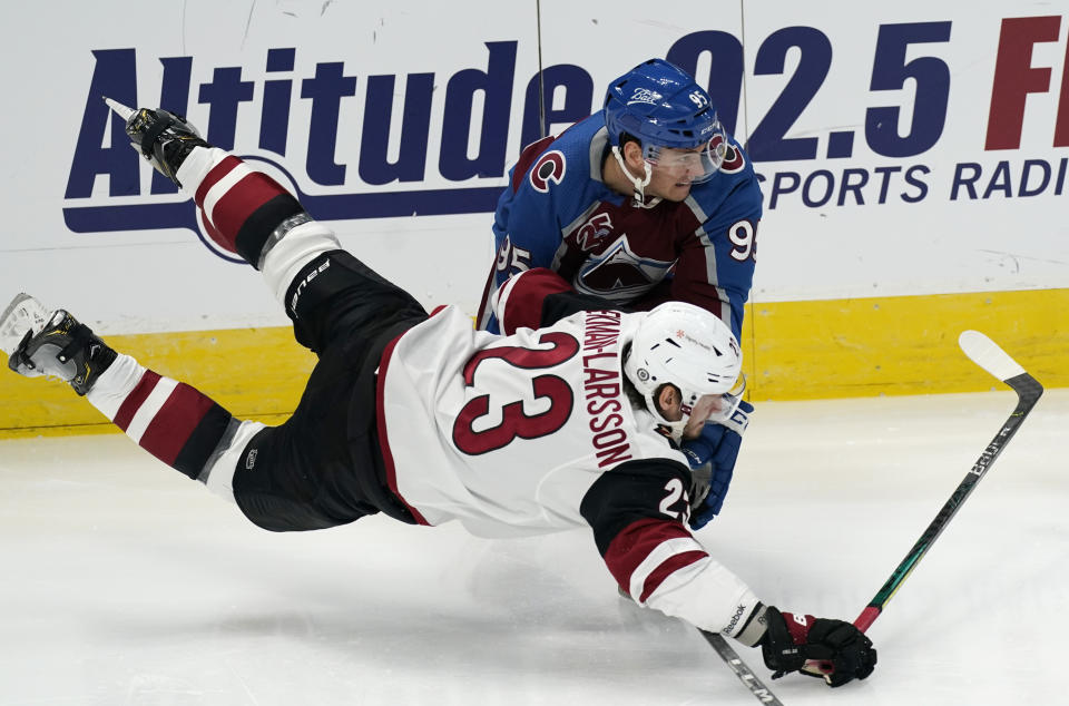 Arizona Coyotes defenseman Oliver Ekman-Larsson, front, falls while pursuing the puck with Colorado Avalanche left wing Andre Burakovsky in the second period of an NHL hockey game Wednesday, March 10, 2021, in Denver. (AP Photo/David Zalubowski)