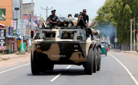 FILE PHOTO: Sri Lankan soldiers patrol a road of Hettipola after a mob attack in a mosque in the nearby village of Kottampitiya