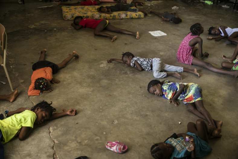 Children sleep on the floor of a school turned into a shelter after they were forced to leave their homes in Cite Soleil due to clashes between armed gangs, in Port-au-Prince, Haiti, July 23, 2022. (Photo by Odelyn Joseph/AP, File)