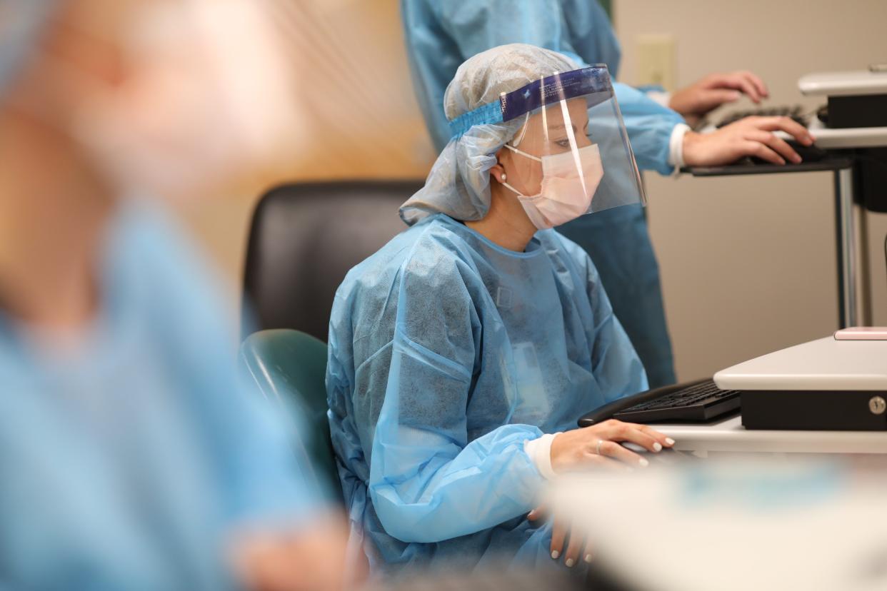 Workers are seen in an IU Health South Central Region COVID testing and treatment area.