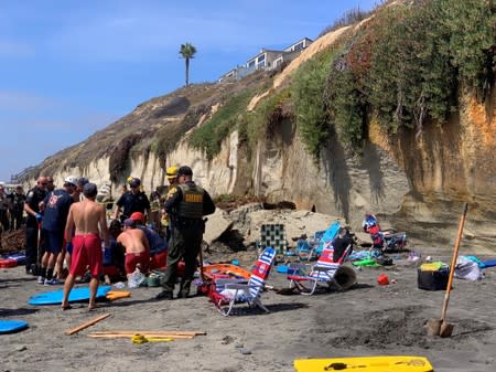 Emergency responders attend to a collapse that has trapped people at a beach in Encinitas, California