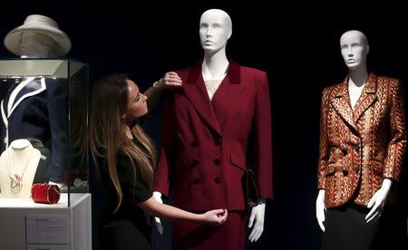 An employee arranges a burgundy wool tweed suit, part of the collection of former British prime minister Margaret Thatcher during an auction preview at Christie's in London, Britain, December 11, 2015. REUTERS/Peter Nicholls