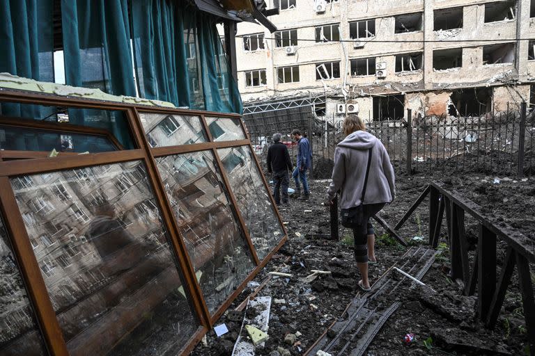 Una mujer camina frente a un edificio destruido en Kramatorsk, en la región de Donetsk, el 18 de septiembre de 2022, en medio de la invasión rusa de Ucrania. (Foto de Juan BARRETO / AFP)