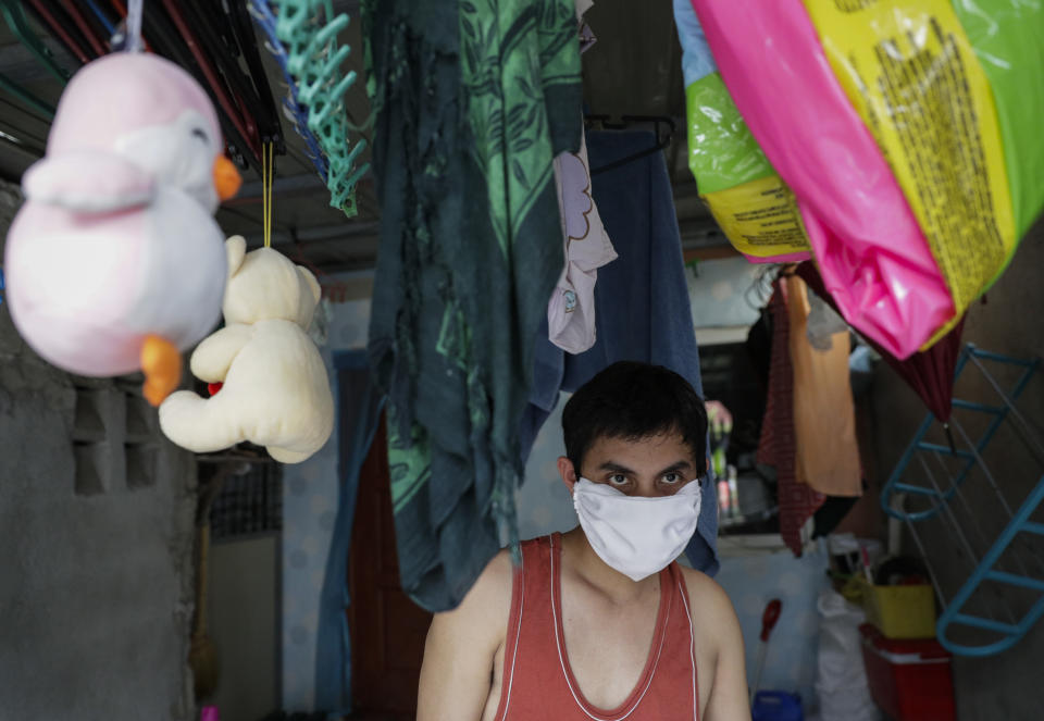 Christopher Bagay, a kitchen crew of the Aida Sol cruise ship in Europe, walks beside children's toys upon arriving at his home in Laguna province, south of Manila, Philippines Thursday, May 28, 2020. Bagay said it took him about two months to go through repetitive quarantines in Spain, Germany and Manila before he was finally allowed to go home. Tens of thousands of workers have returned by plane and ships as the pandemic, lockdowns and economic downturns decimated jobs worldwide in a major blow to the Philippines, a leading source of global labor. (AP Photo/Aaron Favila)