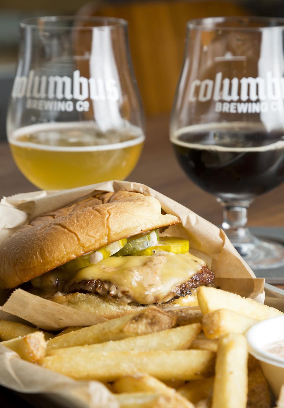 A burger and fries with a beer flight are pictured in July 2021 at the Columbus Brewing Co. Taproom.