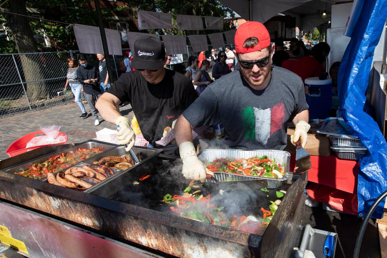 Sal, left, and Mike Carfanga prepare Italian sausages and roasted vegetables at the Carfagna's booth during the 2021 Italian Festival outside St. John the Baptist Catholic Church in Columbus.