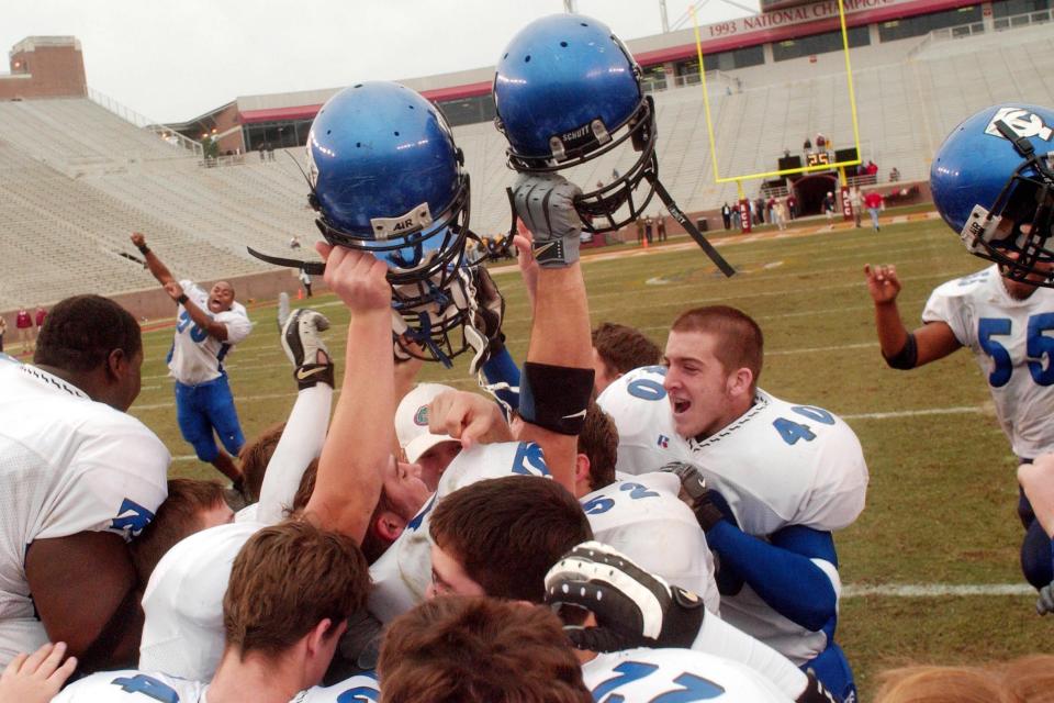 Trinity Christian Academy players celebrate after their 42-7 victory over American Heritage to win the Class A state football championship Thursday in Tallahassee on December 12, 2002. [Rick Wilson/Florida Times-Union]