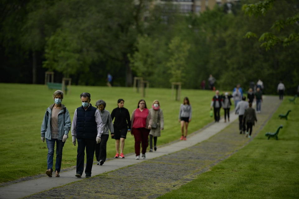 People wearing face masks to protect against coronavirus exercise along Vuelta del Castillo park, in Pamplona, northern Spain, Saturday, May 2, 2020. Spain relaxed its lockdown measures Saturday, allowing people of all ages to leave their homes for short walks or exercise for the first time since March 14. (AP Photo/Alvaro Barrientos)