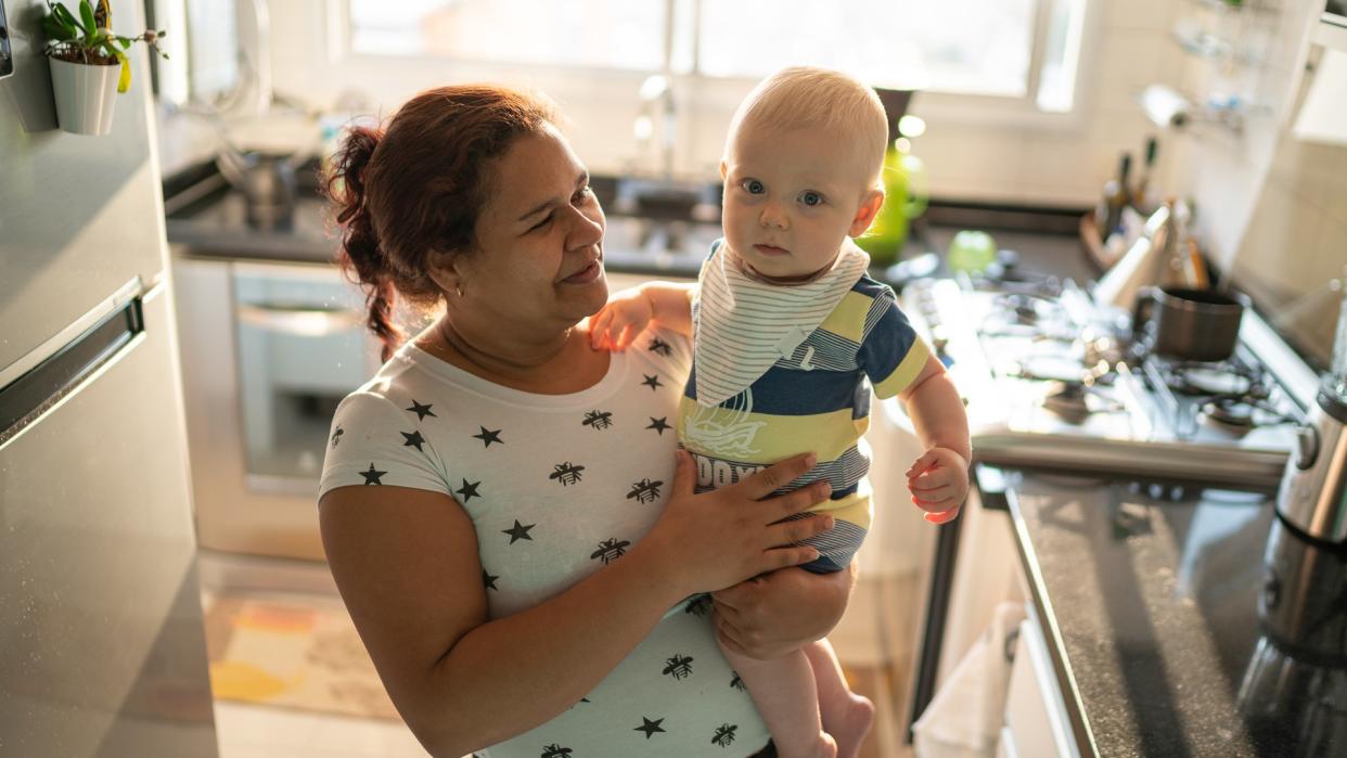 Babysitter and baby boy at kitchen.